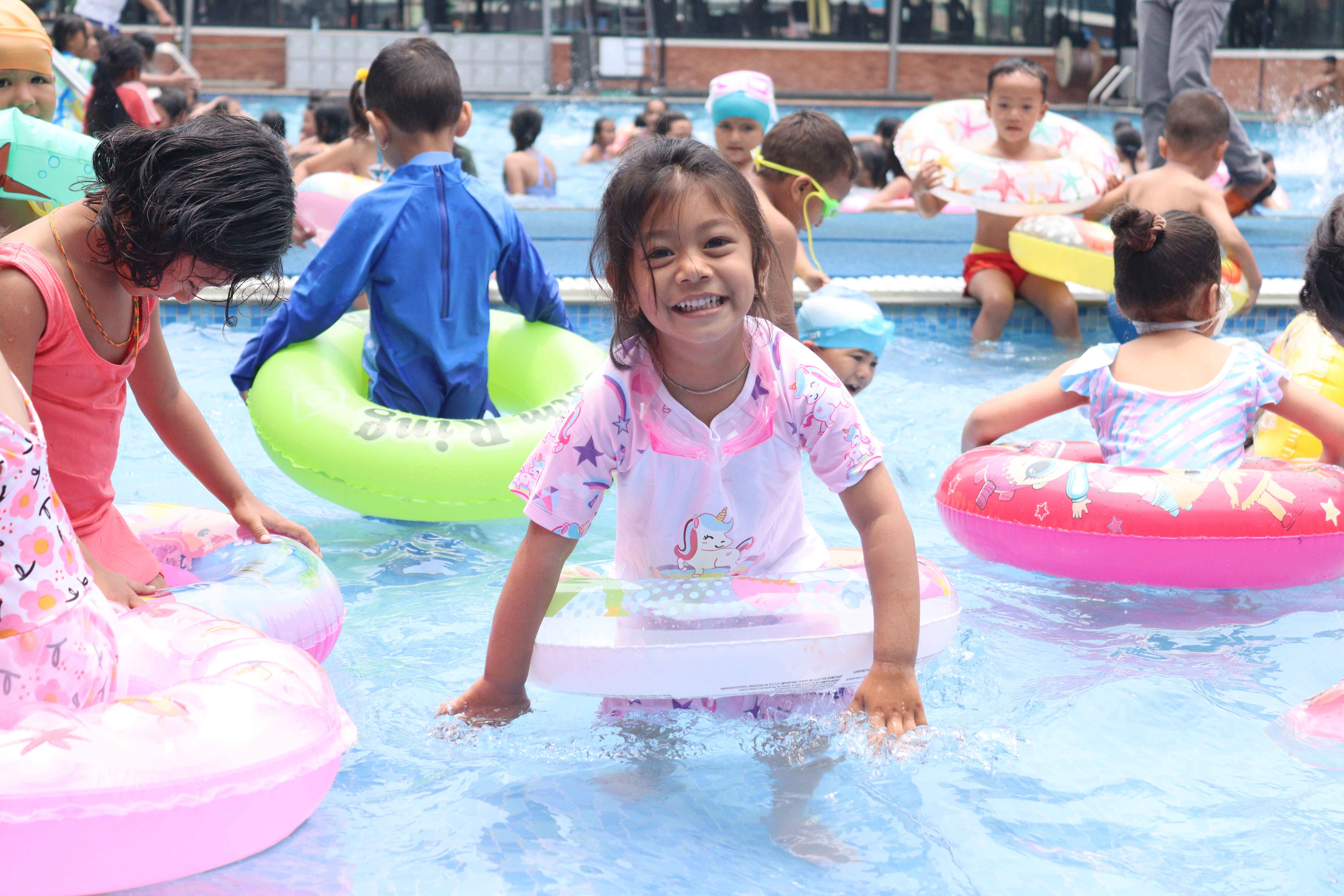 small children are swimming in the pool.