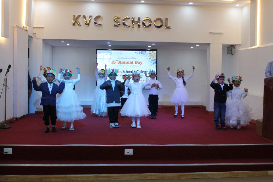 Preschool students in colorful costumes on stage at 15th Annual Day